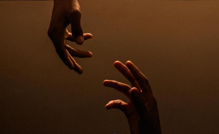 hands reaching out in dramatic light